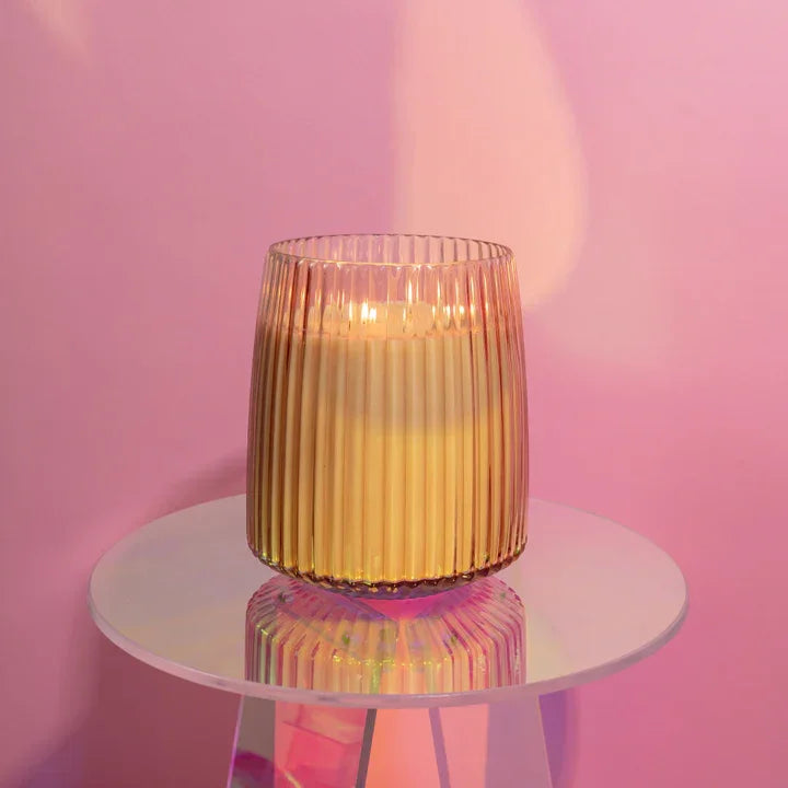 Lit Sweet Grace Jumbo Candle in ribbed glass on white surface with sparkling tea aroma