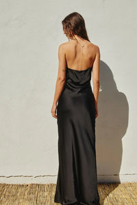 Long black strapless maxi dress worn by a woman, showcasing a flowy silhouette