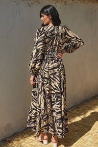 Long-sleeved maxi dress featuring a bold leafy print in brown and beige tones