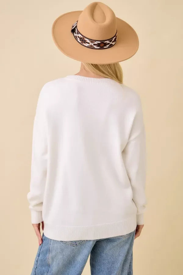 White long-sleeved crewneck sweater with pumpkin truck embroidered patchwork design