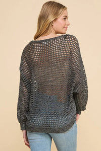 Loose-knit gray long sleeve open weave knit sweater worn by a woman, showcasing style