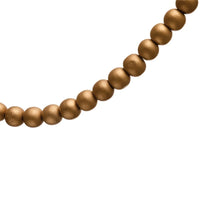 String of matte gold Paulownia wood beads elegantly arranged in a curved line