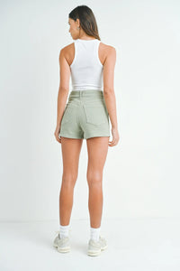 Mint green high-waisted utility cargo shorts with white tank top and sneakers