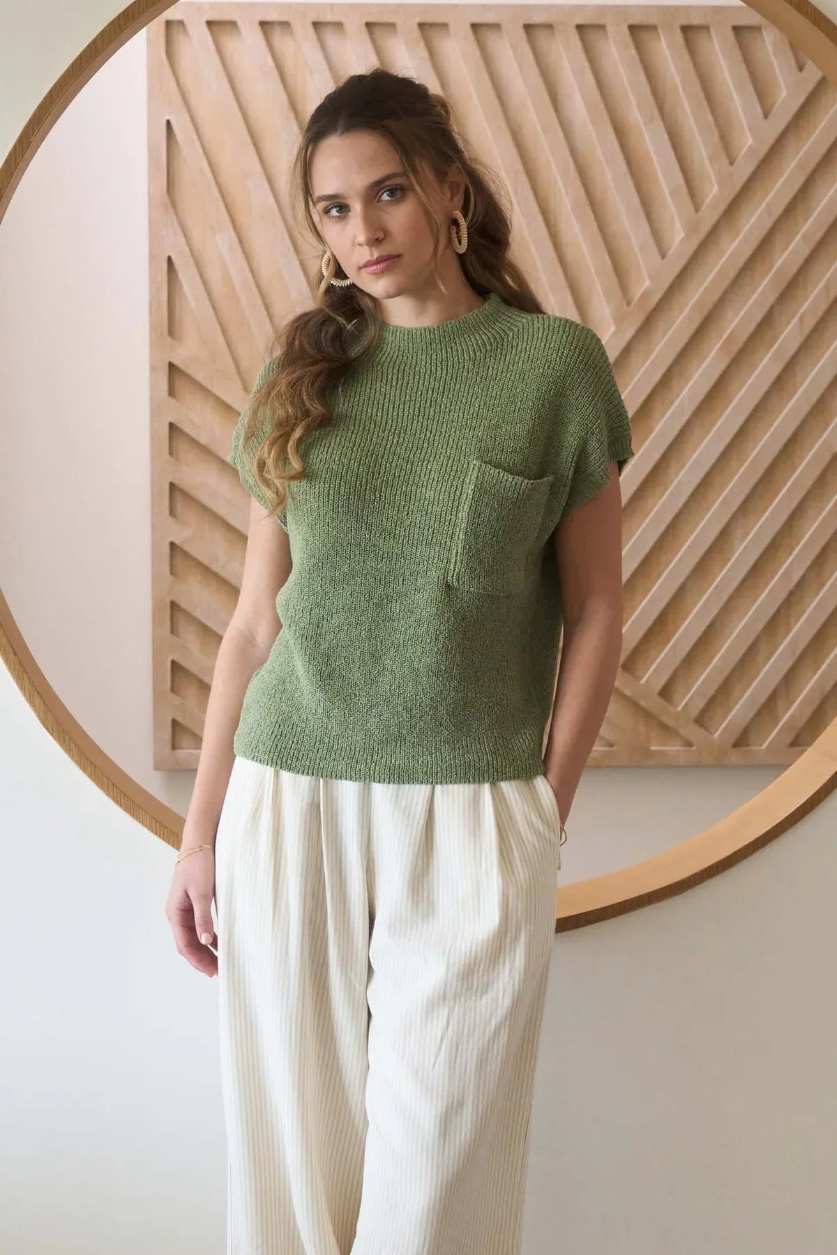 Women’s boho chic look featuring a mock neck sweater with chest pocket and wide-leg cream pants
