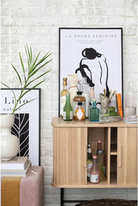 Modern wooden storage cabinet showcasing a hammered glass carafe and decorative items