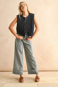 Navy blue cable knitted vest with tie-front design, perfect for a stylish knitted vest look