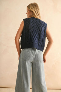 Navy blue cable knitted vest with wide-leg pinstriped jeans for stylish casual wear