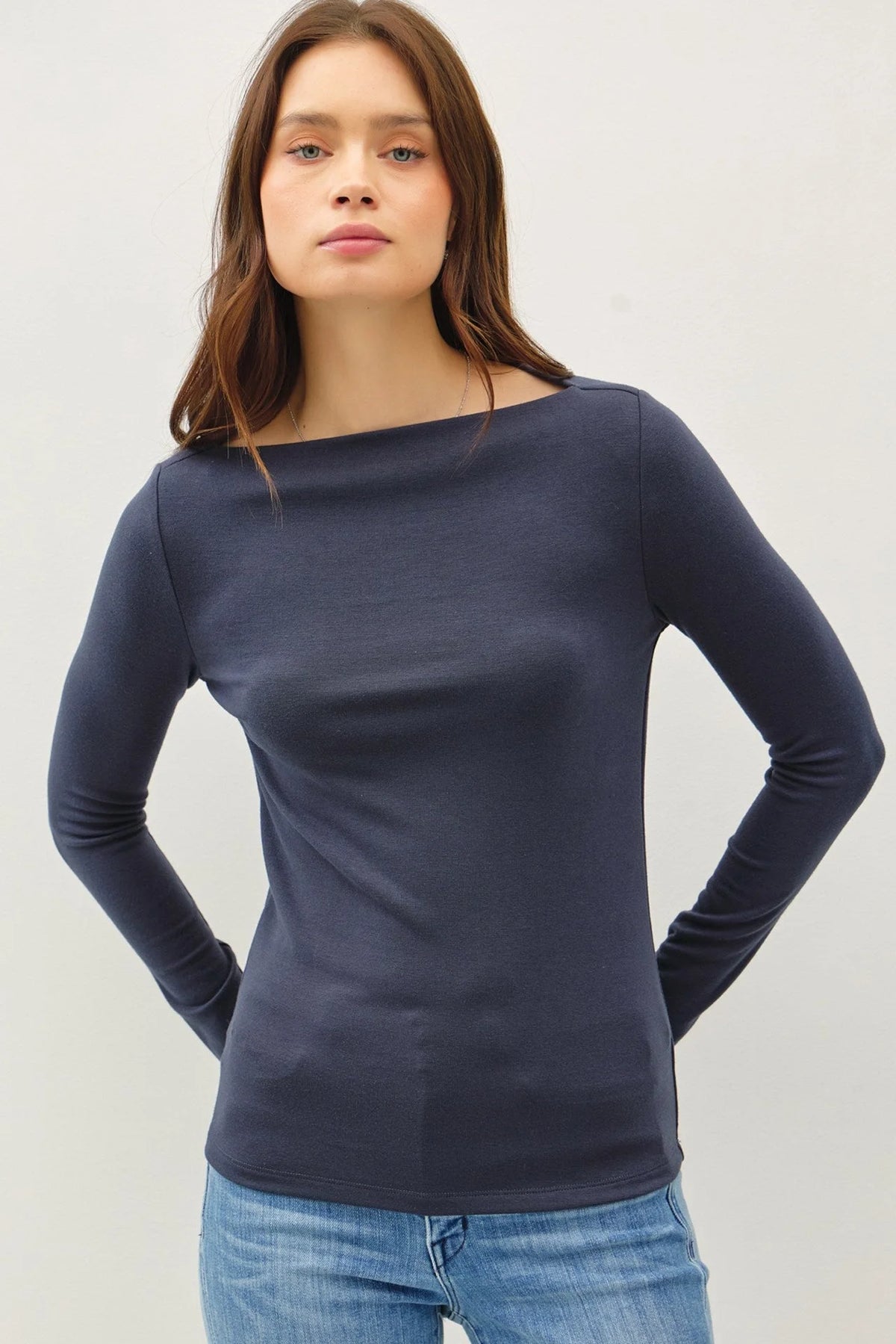 Navy blue long sleeve basic boat neck top paired with blue jeans for a stylish look