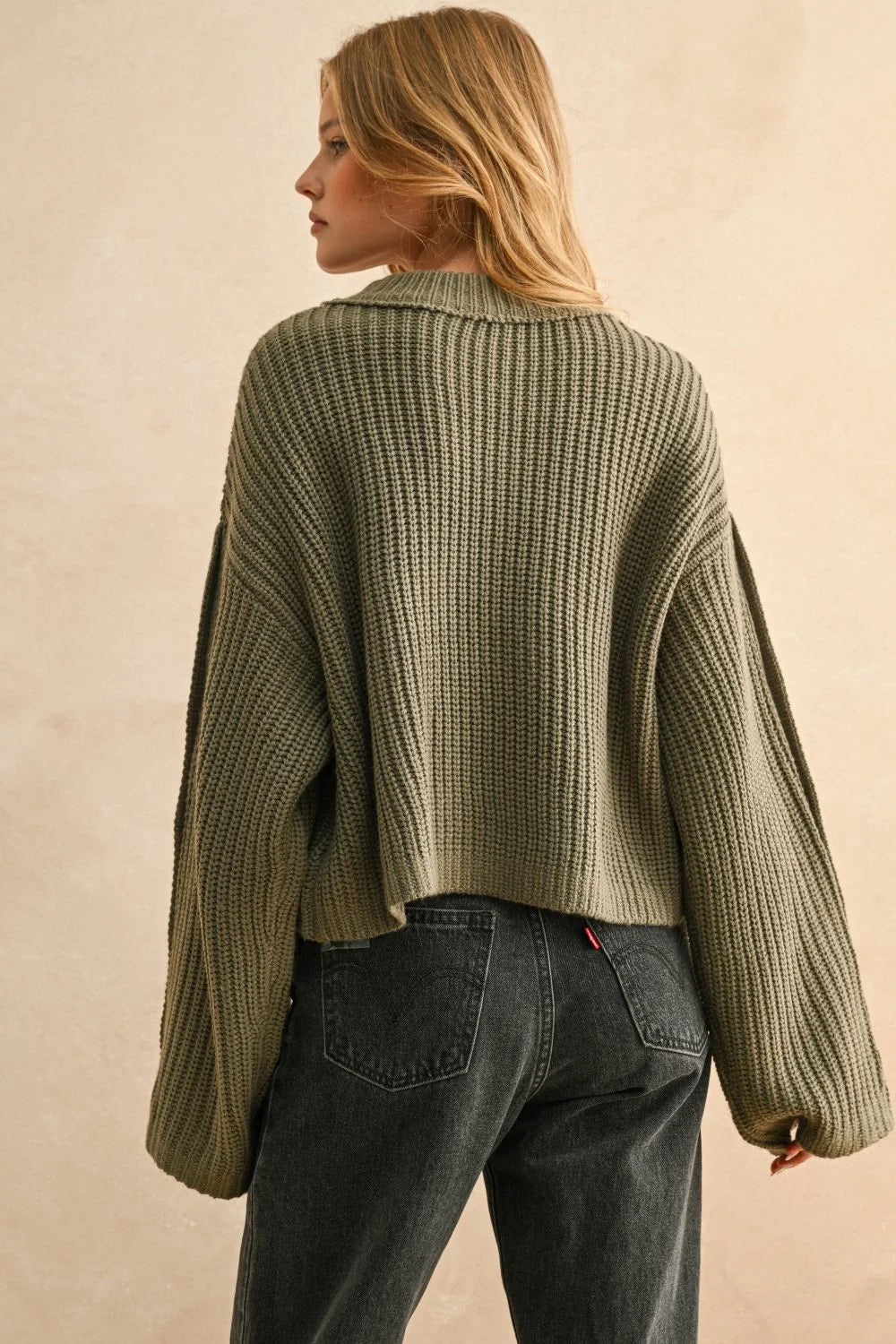 Olive green wide neck long sleeve sweater paired with dark wash straight-leg jeans