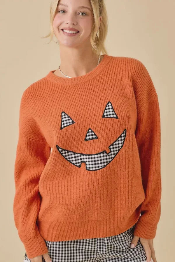 Orange knit Halloween sweater featuring pumpkin face patchwork and festive face patchwork design