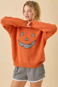 Orange knit Pumpkin Face Patchwork Sweater with gingham Jack-o’-lantern features