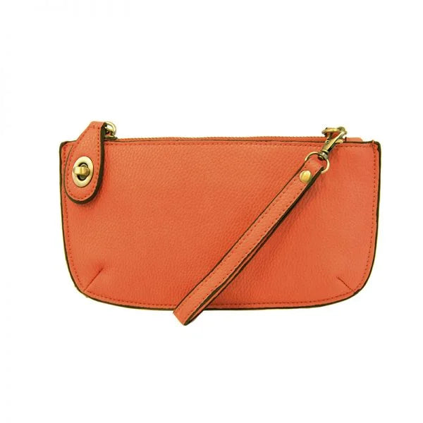 Orange leather wristlet clutch with gold hardware, featuring card slots and detachable strap