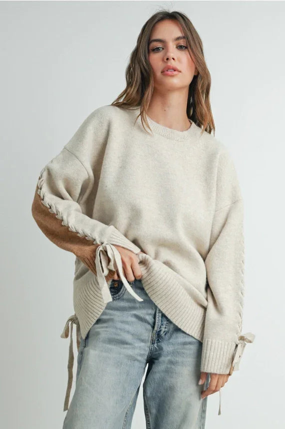 Oversized cream crew neck long sleeve pullover sweater with lace-up sleeve details