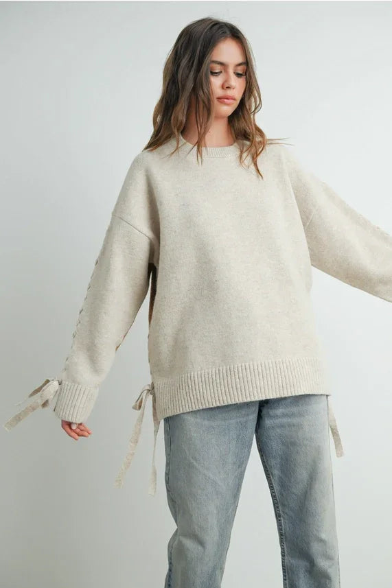 Oversized beige crew neck long sleeve pullover sweater with tie details on sleeves and sides