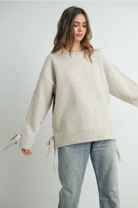 Oversized beige crew neck long sleeve pullover sweater with tie details on sleeves and sides