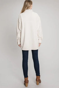 Oversized white knit sweater styled with dark skinny jeans and brown ankle boots over lofty corduroy jacket