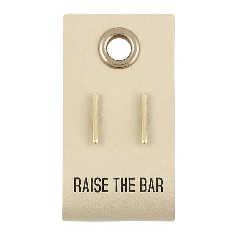 Pair of leather tag gold bar-shaped stud earrings on a card with RAISE THE BAR design