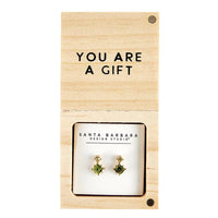 Pair of green and gold stud earrings displayed on a gift card for women’s boho chic clothing