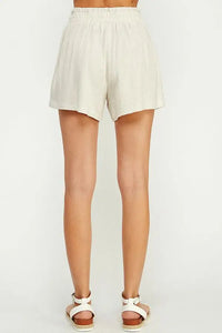 Light-colored linen blend shorts with double buckle worn on a person’s lower body