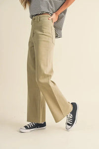 Pair of wide leg denim pants styled with a striped top and sneakers for a chic look