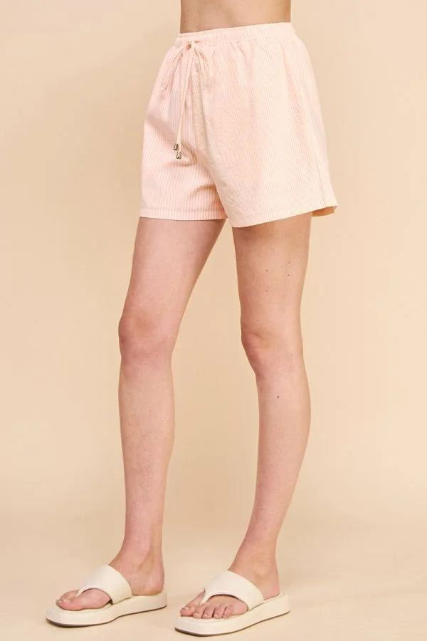 Pale pink stripe cotton blend adjustable tie shorts worn on a person’s lower body