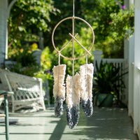 Peace sign dream catcher with black and white feathers on natural cane hoop