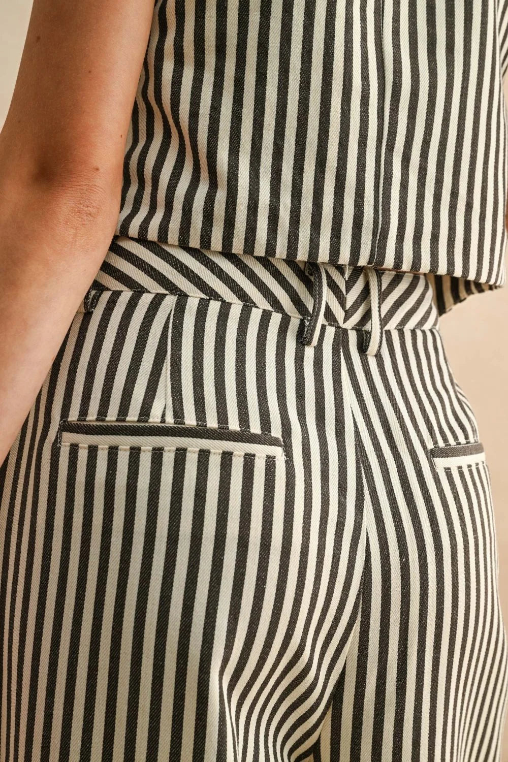 Model wearing striped pattern wide leg pants in black and white striped top and trousers