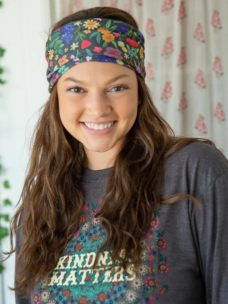 Smiling person in a floral headband and Kindness Matters t-shirt showcasing boho style