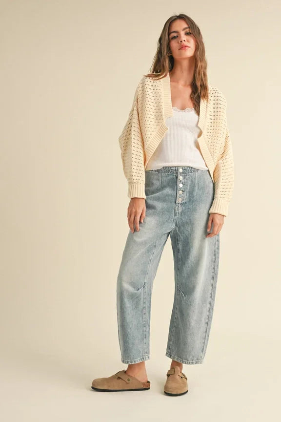 Person in cream cardigan and light-wash jeans showcases Shop Daisy’s women’s boho chic clothing