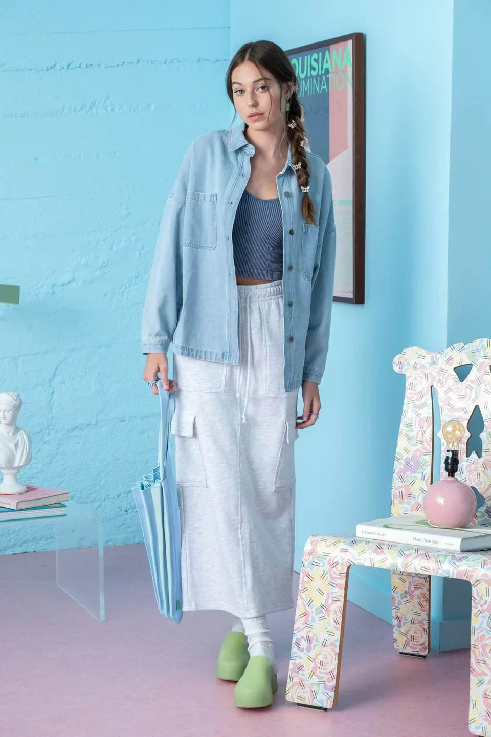 Person in solid denim shacket, gray crop top, white maxi skirt, and green slippers