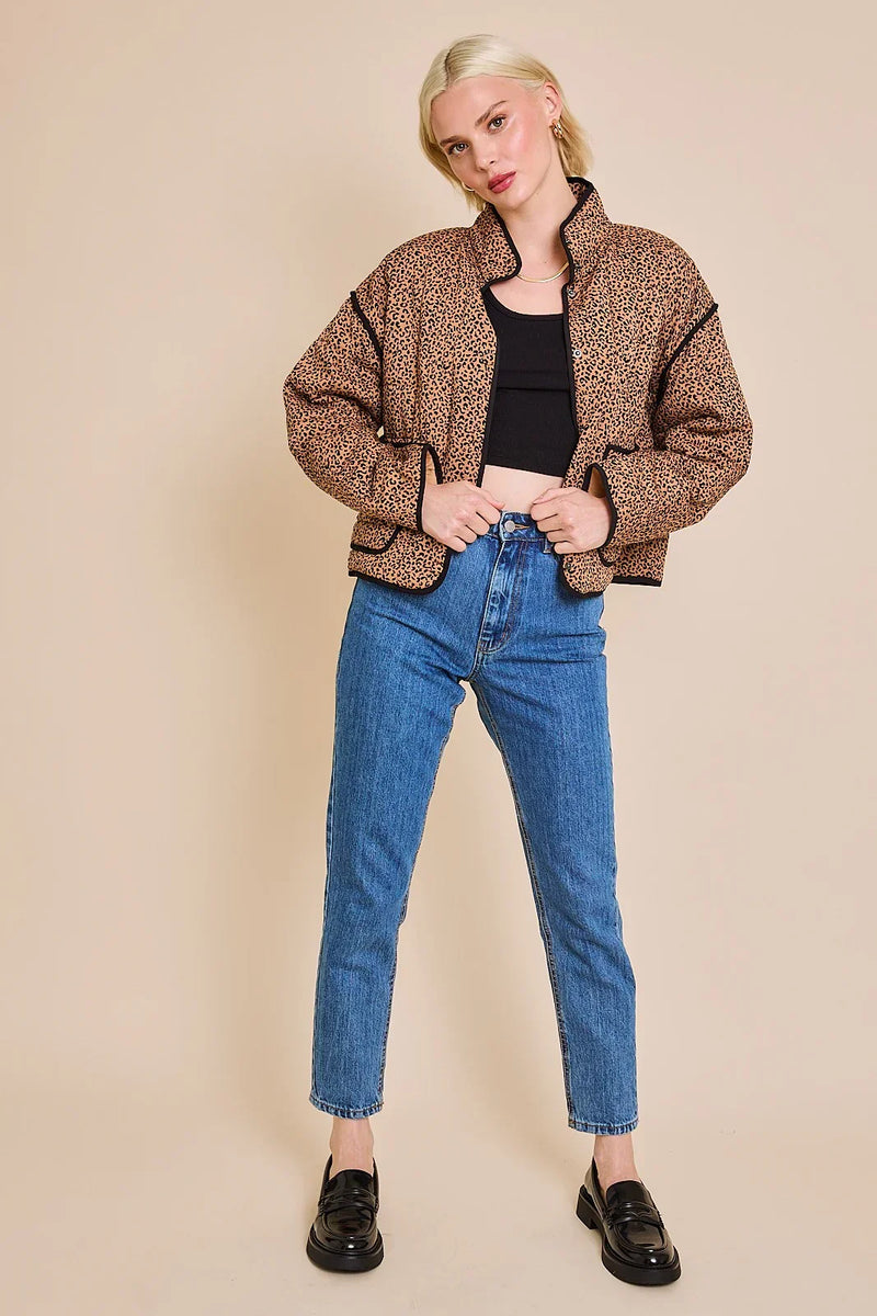 Person in leopard print bomber jacket and blue jeans showcasing a stylish drop shoulder jacket