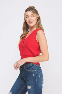 Person in a red sleeveless top and distressed jeans wearing a Pointelle Knit Button Vest