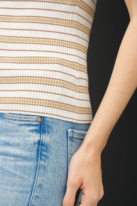Person wearing stripe ribbed knit tank top with light-wash blue jeans