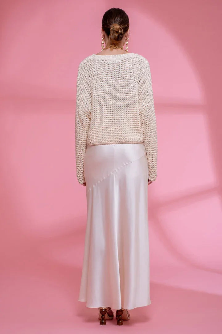 Person in a white crochet knit sweater and long skirt, showcasing women’s boho chic clothing