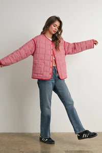 Buttoned quilted puffer jacket with black Adidas sneakers and blue jeans