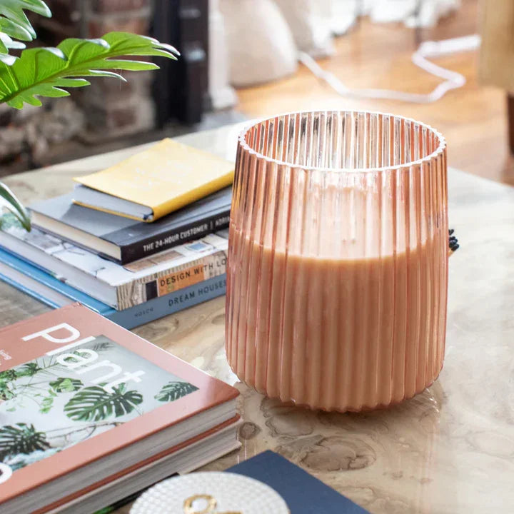 Pink ribbed glass candle holder with lit Sweet Grace Jumbo Candle in Sparkling Tea scent