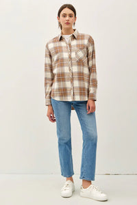 Plaid pocket oversize flannel in neutral tones paired with blue jeans and white sneakers