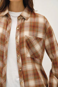 Plaid oversized flannel shirt in earthy tones over white undershirt for a classic look