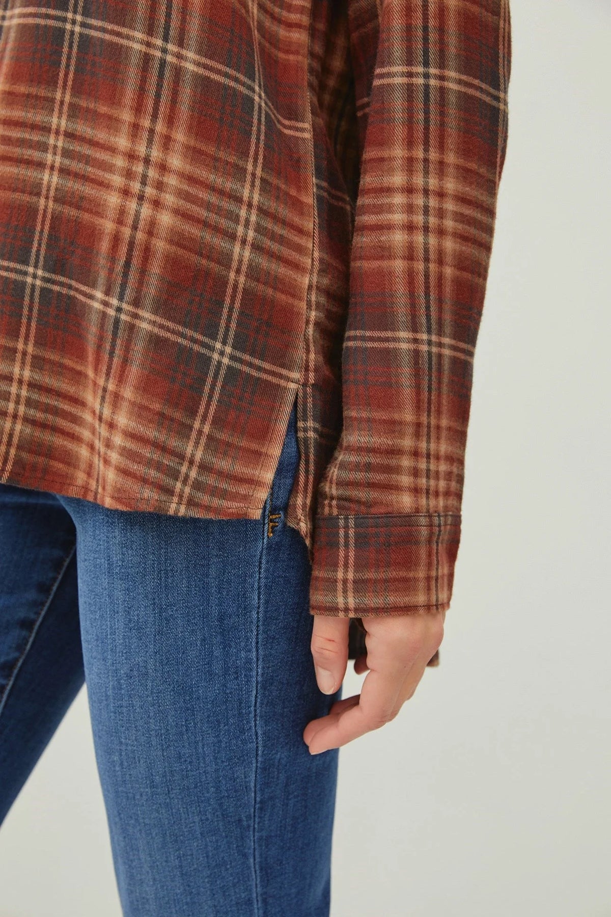 Classic button down flannel shirt with side slit, styled over blue jeans