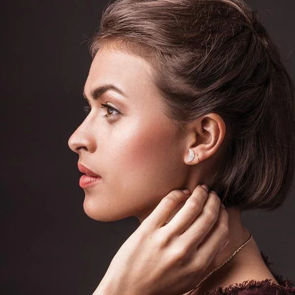 Profile view of a woman with brown hair and red lipstick wearing CRESCENT MOON STUD EARRING, embodying boho charm