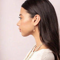 Profile view of a woman showcasing Floating Stone Earring with long dark hair