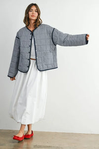 Buttoned quilted puffer jacket in black white checkered pattern with red trim