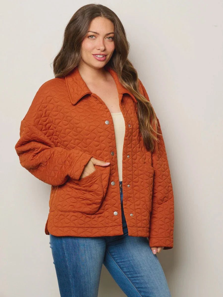 Quilted orange jacket with collar and pockets over white top and blue jeans from Shop Daisy