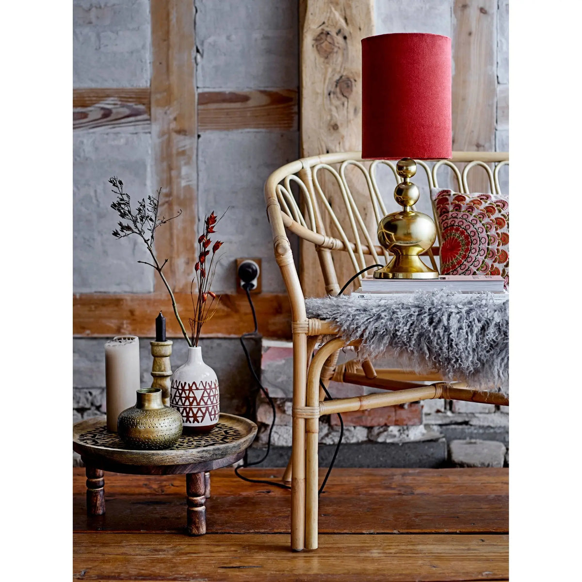 Rattan chair with fan-like backrest beside Antique Brass Debossed Metal Vase