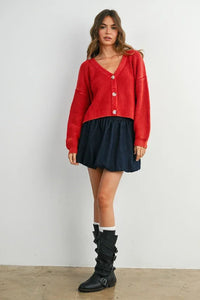 Red neck buttoned ribbed long sleeve cardigan with navy mini skirt and black buckle boots