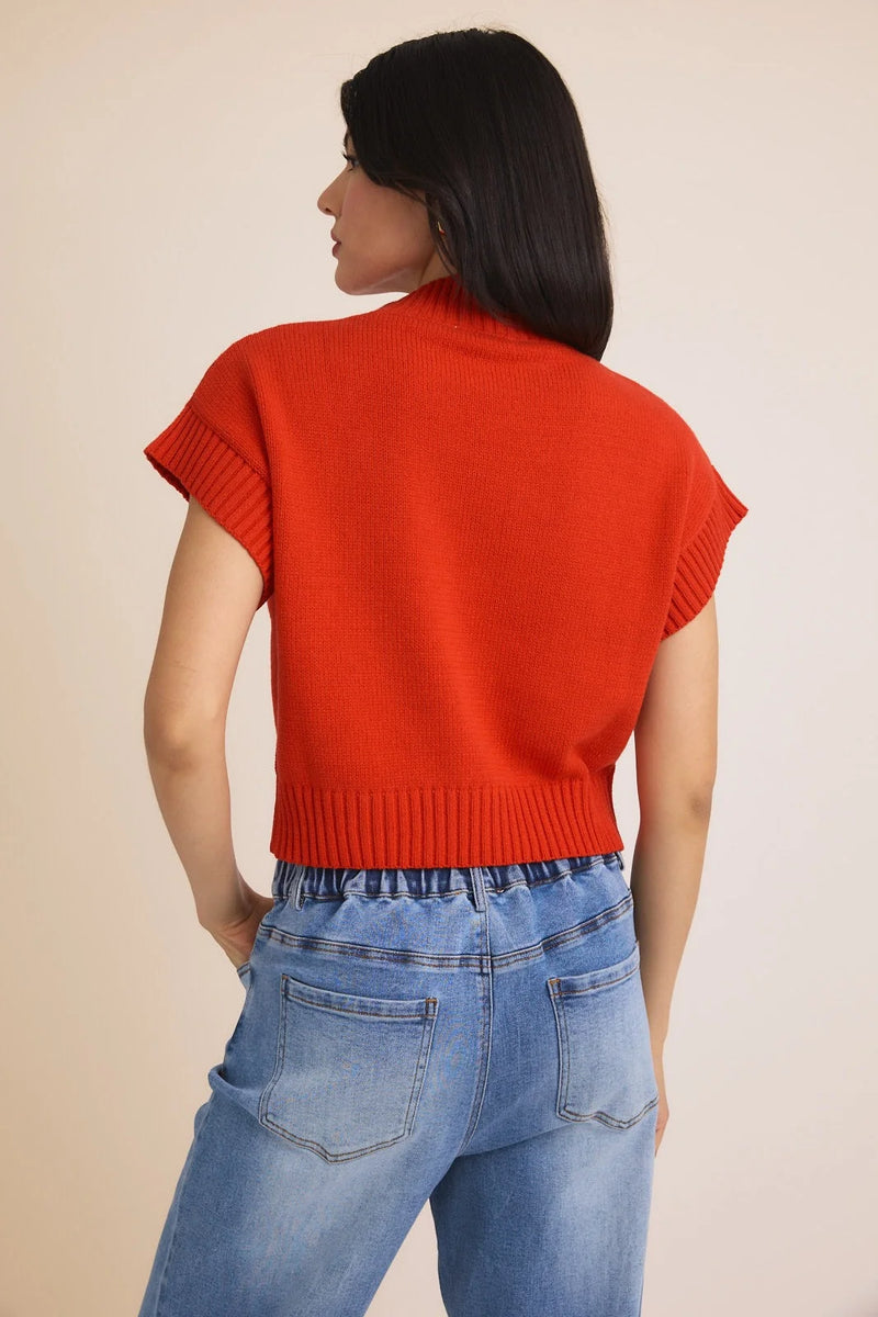 Red knit cropped mock neck wide shoulder heart sweater vest with cap sleeves and light wash jeans