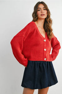Red neck buttoned ribbed long sleeve cardigan over a dark blue mini skirt