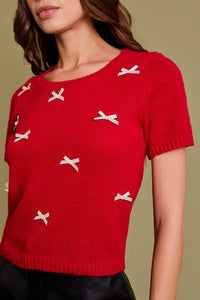 Red short-sleeved sweater with white bows, ideal for women’s boho chic clothing at Shop Daisy