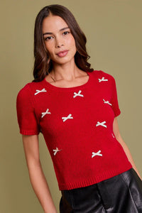 Red short-sleeved sweater with white bows, perfect for women’s boho chic clothing at Shop Daisy