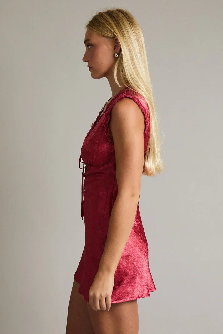 Red sleeveless mini dress with lace detailing and tie-up front